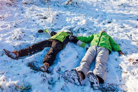 Young Couple In Love Lying In Snow And Making Snow Angels People