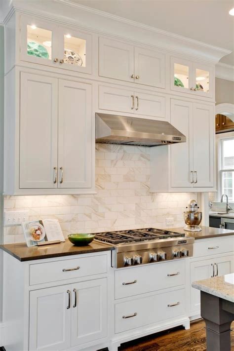 crisp white shaker cabinets and a marble subway tile backsplash lend an elegant vibe … shaker