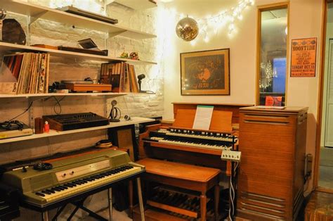 An Old Fashioned Organ Sits In The Corner Of A Room With Bookshelves