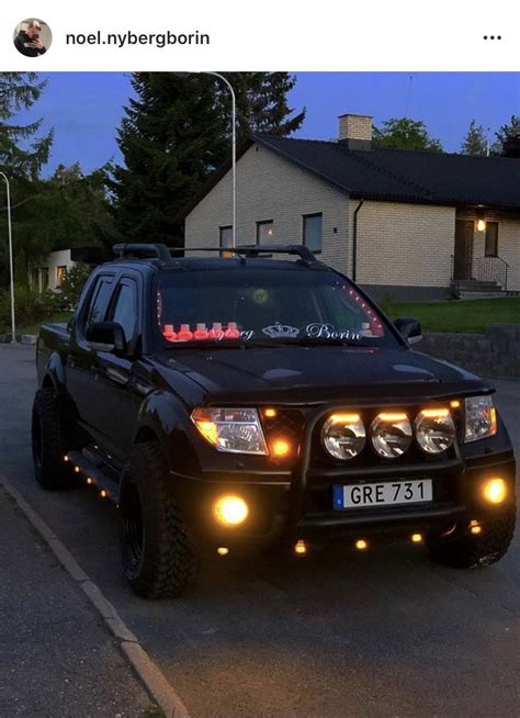 A Black Suv Parked In Front Of A House At Night With Its Lights Turned On