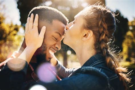 interracial couple forehead kiss and smile in nature for love bonding and embracing