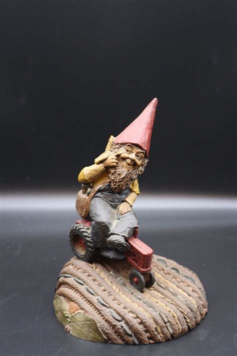 A Gnome Figurine Sitting On Top Of A Rock