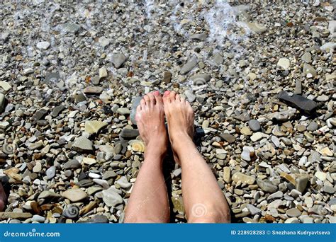Women S Feet Lie On A Pebble Beach Washed By Sea Water Stock Image Image Of Foot Shore