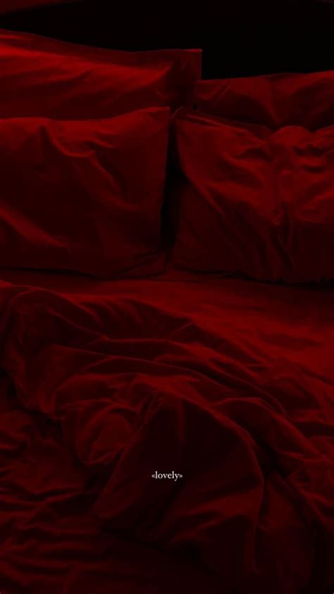 A Bed With Red Sheets And Pillows On It