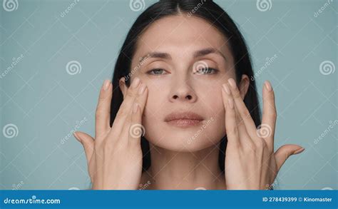 A Young Woman Massages Her Face With Gentle Movements Touches Her