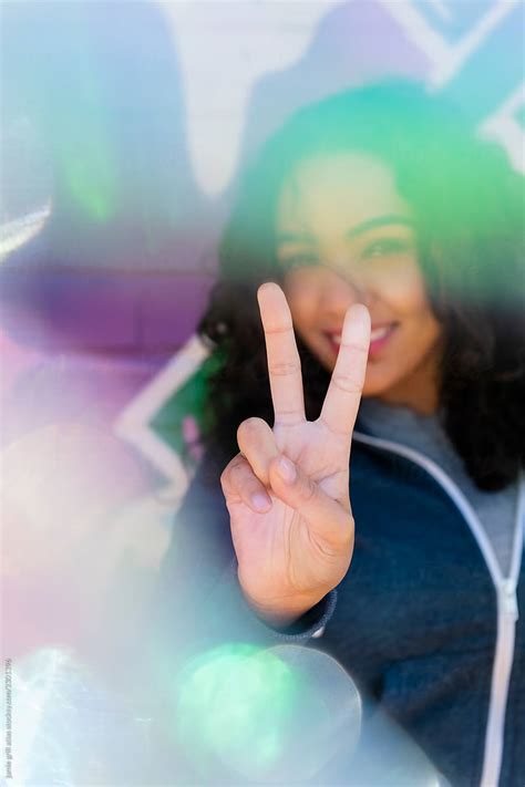 Woman Giving Peace Sign On City Street By Stocksy Contributor Jamie