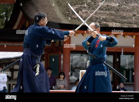 Two Men Engaged In A Sword Fight Using Real Samurai Swords During A Martial Arts Demonstration