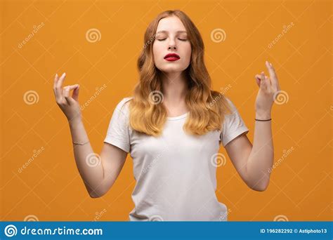 Young Pretty Woman With Wavy Redhead Keeps Hands In Mudra Gesture Holds Fingers In Yoga Sign
