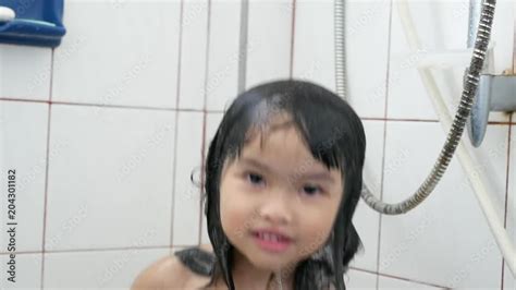 asian girl taking a shower be smile funny and happiness wet hair taking shower in bath with