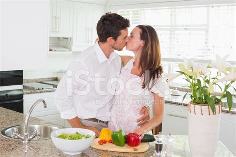 Loving Couple Kissing In The Kitchen Stock Photo Royalty Free