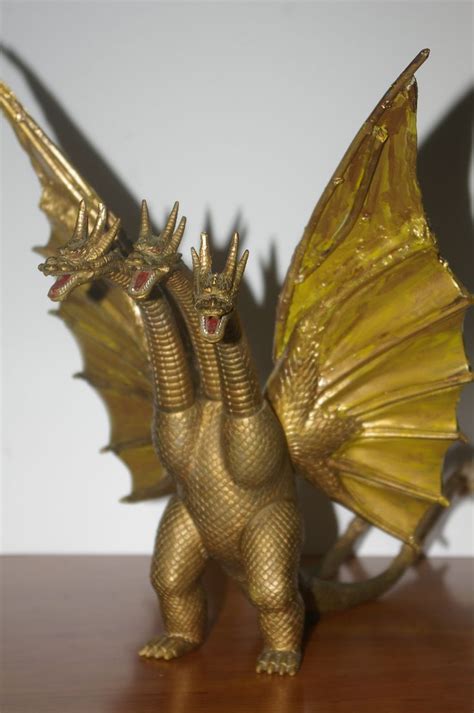 A Golden Dragon Figurine Sitting On Top Of A Wooden Table