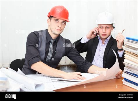 Architect And Construction Engineer Discussing Plan In Office Room