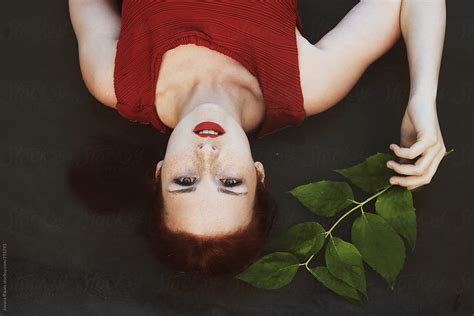 Beautiful Redhead Woman Lying Down On Water And Looking At Camera Del Colaborador De Stocksy