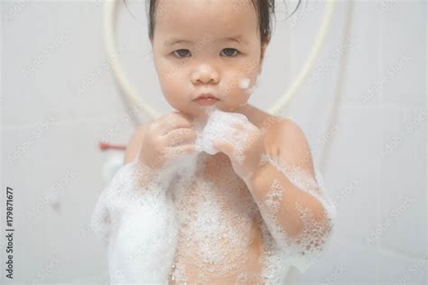 Little Asian Girl Taking Shower In Bathroom Playing Bath Foam Bubbles Selective Focus Stock