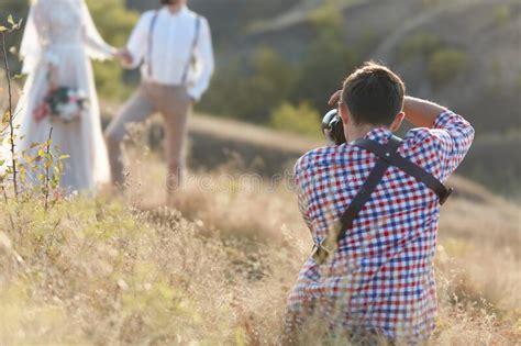 Wedding Photographer Takes Pictures Of Bride And Groom Stock Photo