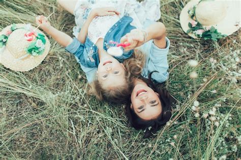 La Joven Madre Y Su Hija Con Caramelos Sobre La Hierba Verde Foto Gratis