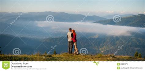 Romantic Couple Enjoying A Morning Haze Over The Mountains Stock Photo
