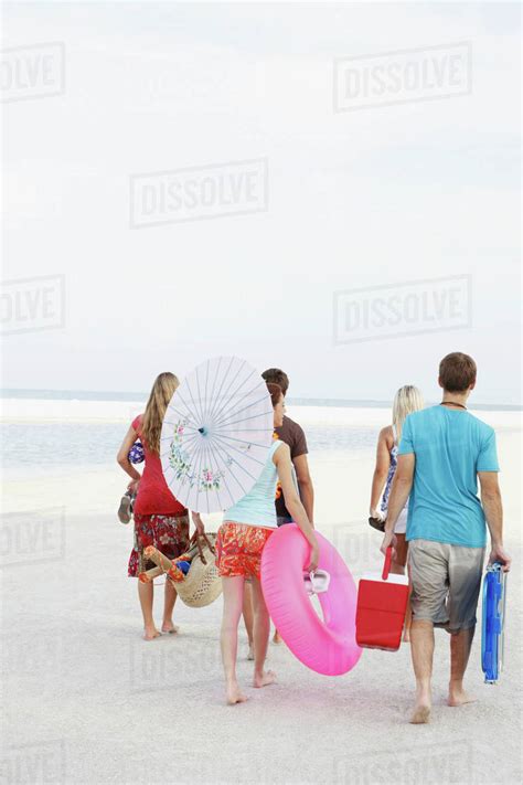 Friends Walking With Beach Essentials Stock Photo Dissolve