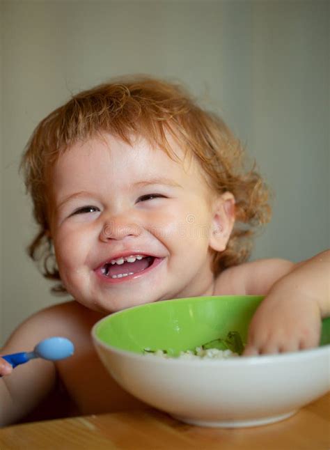 Funny Baby Eating Food Himself With A Spoon On Kitchen Funny Child