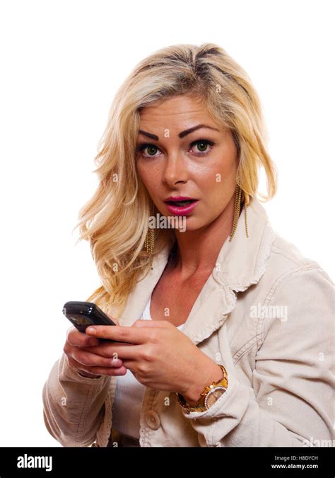 A Woman Has A Amused Look On Her Face While She Is Holding Her Cell Phone And Texting Stock