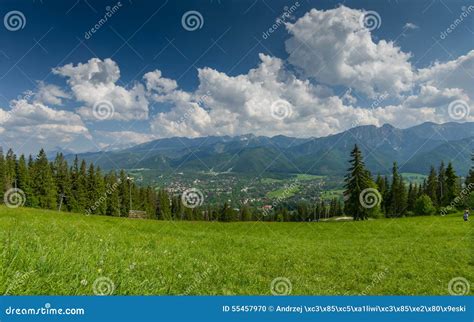 Mountain Landscape With Green Meadow And Town In The Valley Stock
