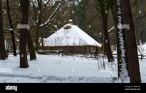 Old Wooden Log House Covered With Snow In A Winter Forest Stock Photo