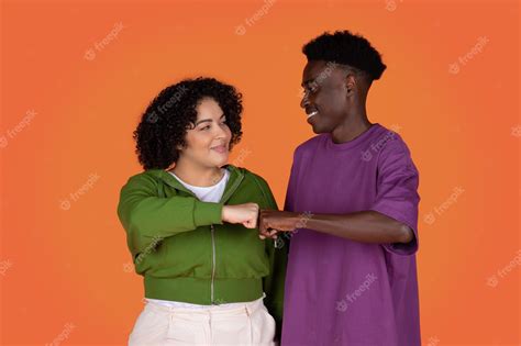 Premium Photo Happy Mixed Race Couple Give Fist Bump Over Red Background