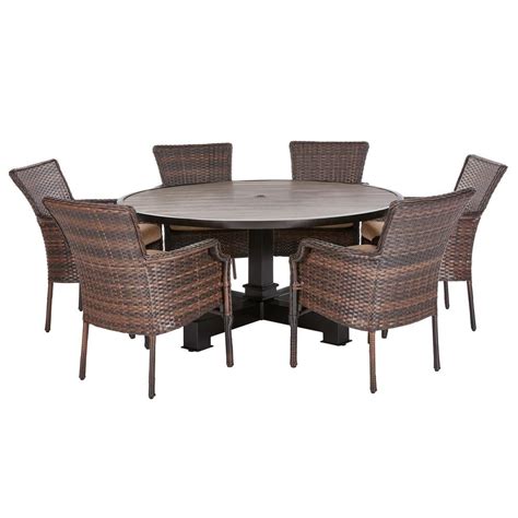 Brown wicker outdoor sofas with dark gray cushions furnish a covered patio with a brick fireplace along with a set of wicker chairs with white cushions. Hampton Bay Grayson Brown 7-Piece Wicker Round Outdoor ...