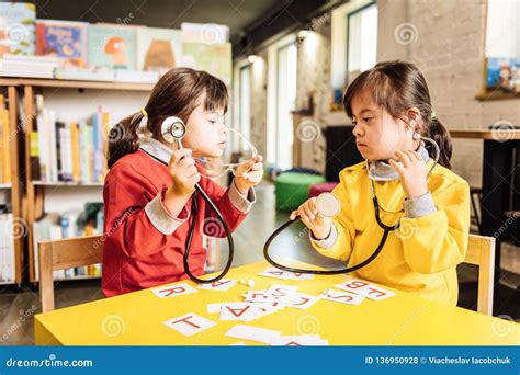 Two Sunny Children Pretending To Be Doctors Playing In Kindergarten
