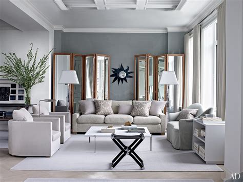 A spacious living room with grey and coral furniture, a white coffee table, a rustic console table, a faux animal skin. Inspiring Gray Living Room Ideas Photos | Architectural Digest