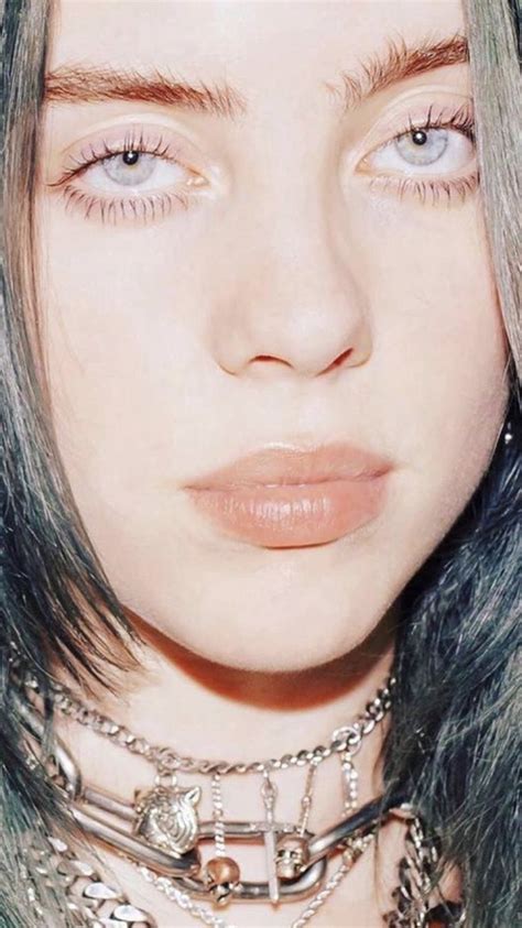 A Close Up Of A Person With Long Hair And Piercings On Her Face