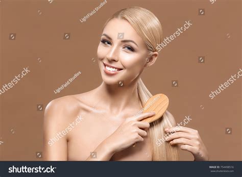 Charming Blonde Naked Woman Combing Long Stock Photo