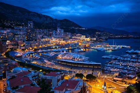 モナコ モンテカルロ港の航空写真と夕方の青い時間のライトアップされた街のスカイライン 夕暮れ時のモナコ港の夜景 豪華なヨットと夜のモナコの景色