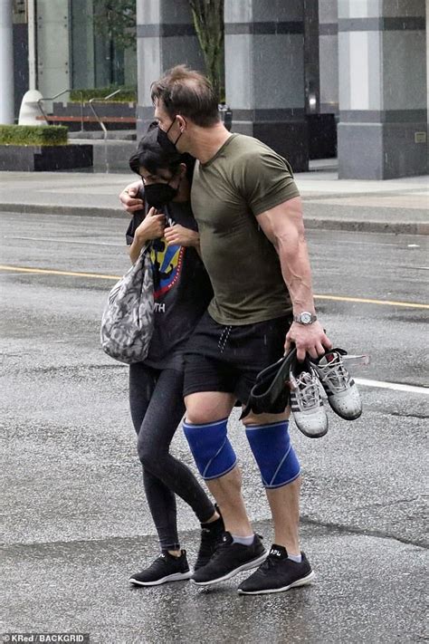 john cena kisses his wife shay shariatzadeh as he leaves the vancouver gym in the pouring rain