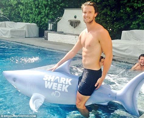 patrick schwarzenegger shows off buff chest while riding blow up shark daily mail online