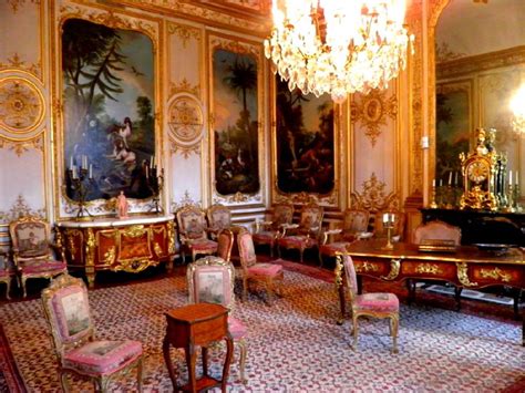 An Ornately Decorated Room With Chandeliers And Paintings