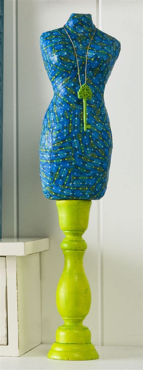 A Blue And Green Vase Sitting On Top Of A White Shelf Next To A Window