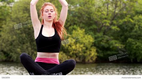 Calm Redhead Doing Yoga By A Lake Stock Video Footage