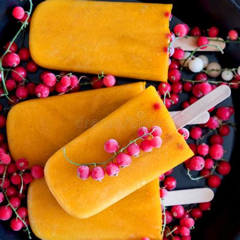 Yellow Popsicle And Frozen Berry On Black Plate Sqare Summer Healthy