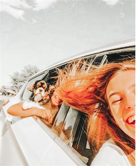 A Woman Sitting In The Passenger Seat Of A Car With Her Hair Blowing In The Wind