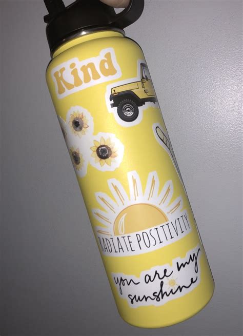 A Yellow And Black Water Bottle Hanging From The Side Of A Wall With