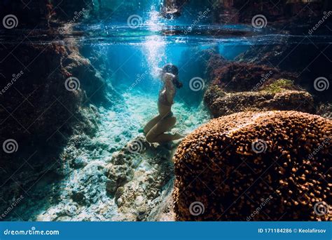 Woman In Bikini Posing Underwater Near Corals In Blue Ocean Stock