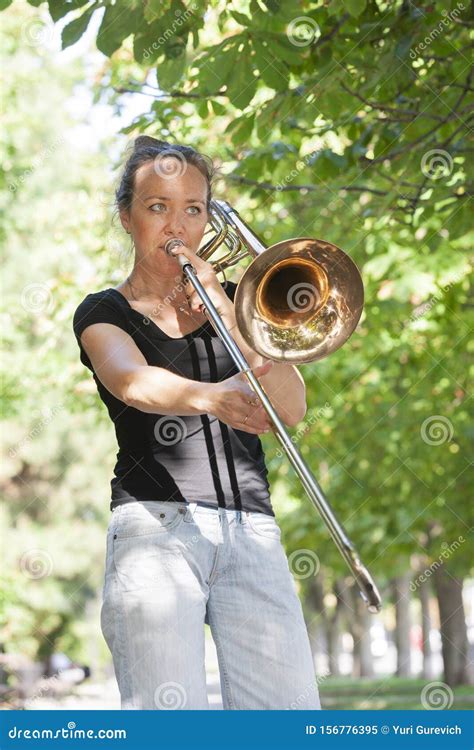 Girl Learning To Play Trombone Girl Plays Standing On The Alley Of A