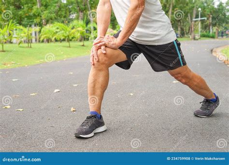 An Old Man With Legs Muscle While Warming Up Exercise Before Running Or