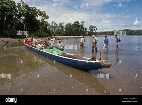 American Tourists Boarding A Dugout Canoe For A Trip Along The Napo