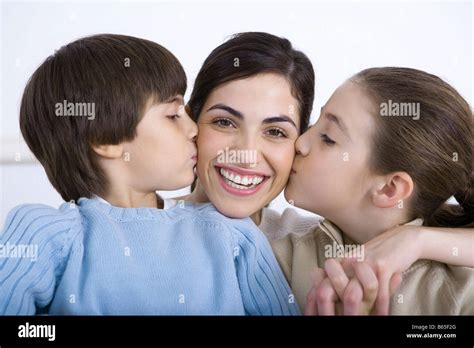 Portrait Of Smiling Mother Being Kissed On Each Cheek By Daughter And