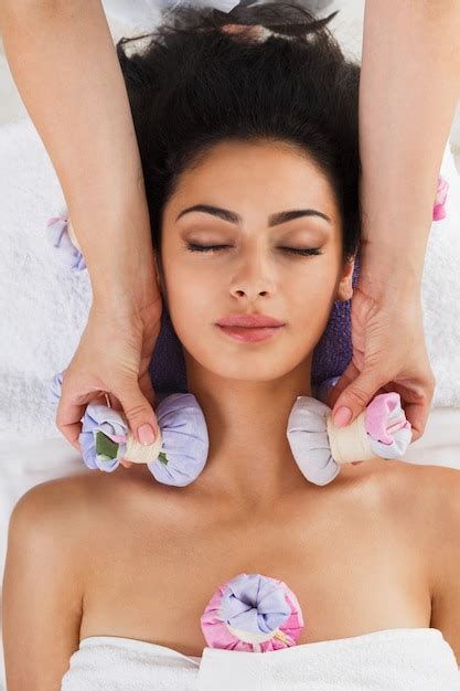 premium photo woman has herbal ball massage in ayurveda spa wellness center