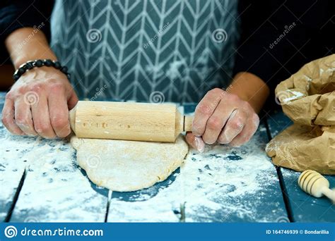 Baker Hands Preparing Fresh Dough With Rolling Pin On Kitchen Table