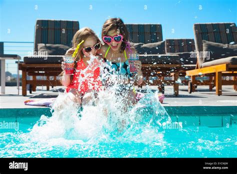 Girls Sitting On Poolside Splashing Water Stock Photo Alamy