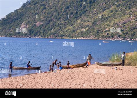 Africa Malawi Cape Maclear Lake Malawi People With Dugout Canoes On